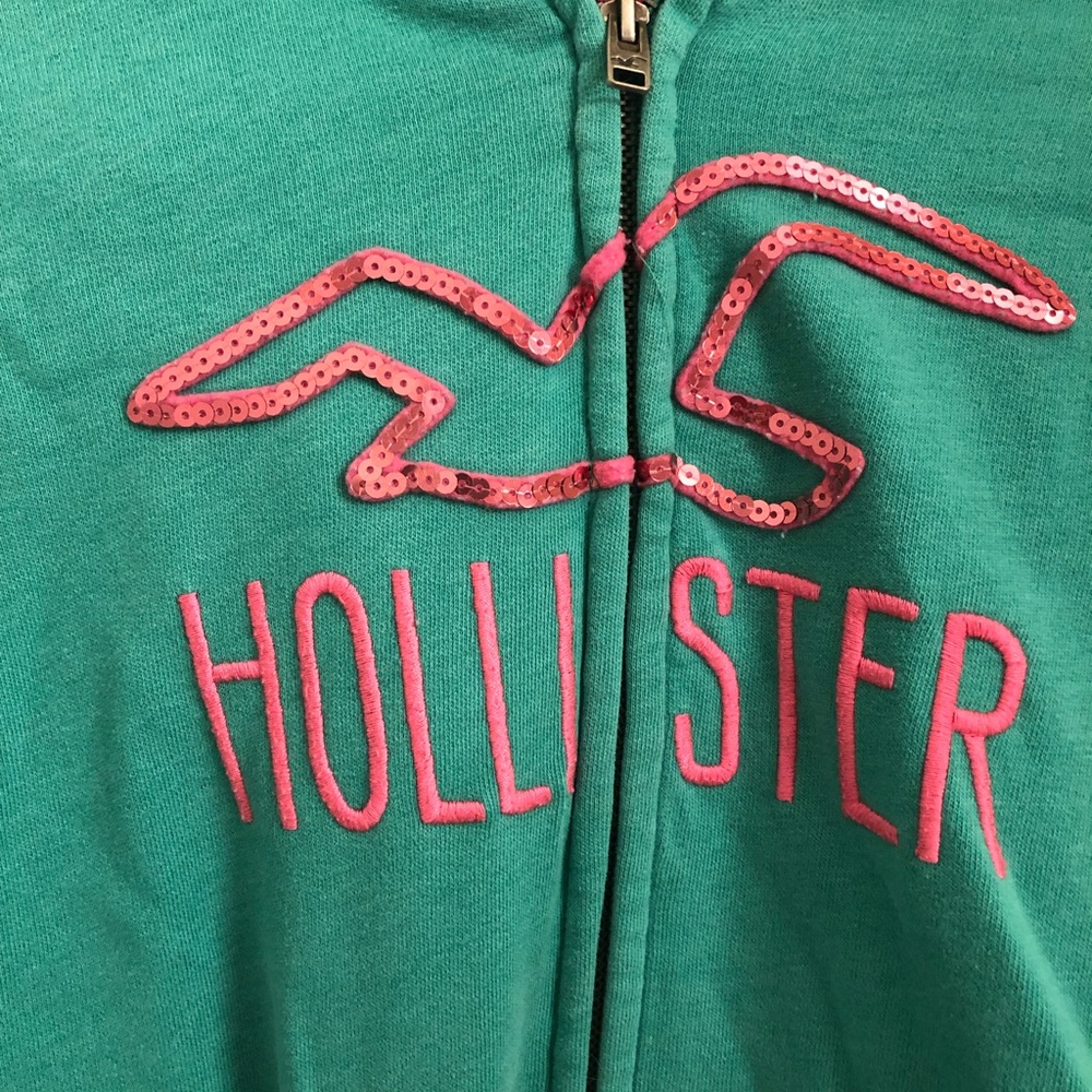 Green-blue hooded jacket with pink accents